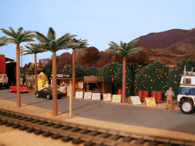 Fruit and vegetable signs line the street near the fruit stand 