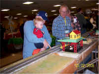 Dave Blaufuss of Dave's S Gauge Trains looks on while a young guest operates the log loader.